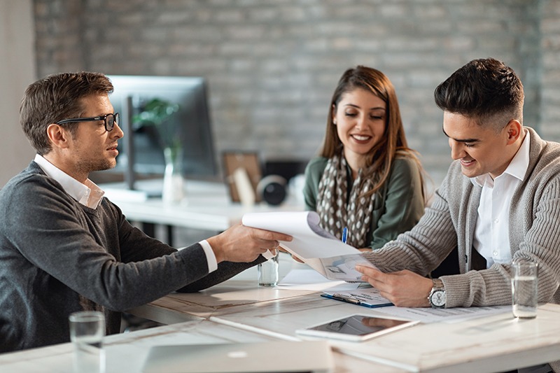 Mortgage & Finance Services Young smiling couple signing a contract